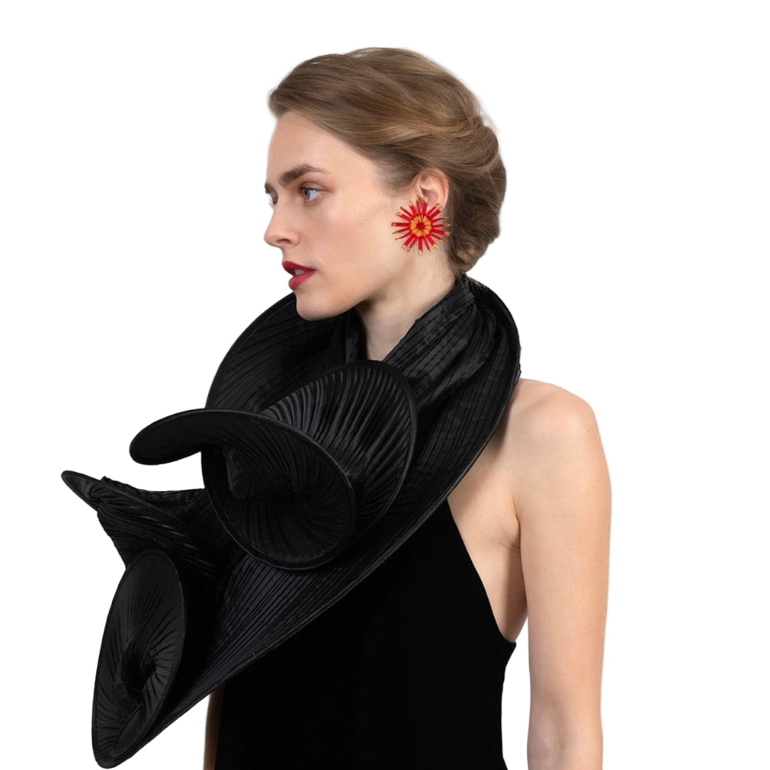 Woman wearing a black scarf and red floral earrings on a white background