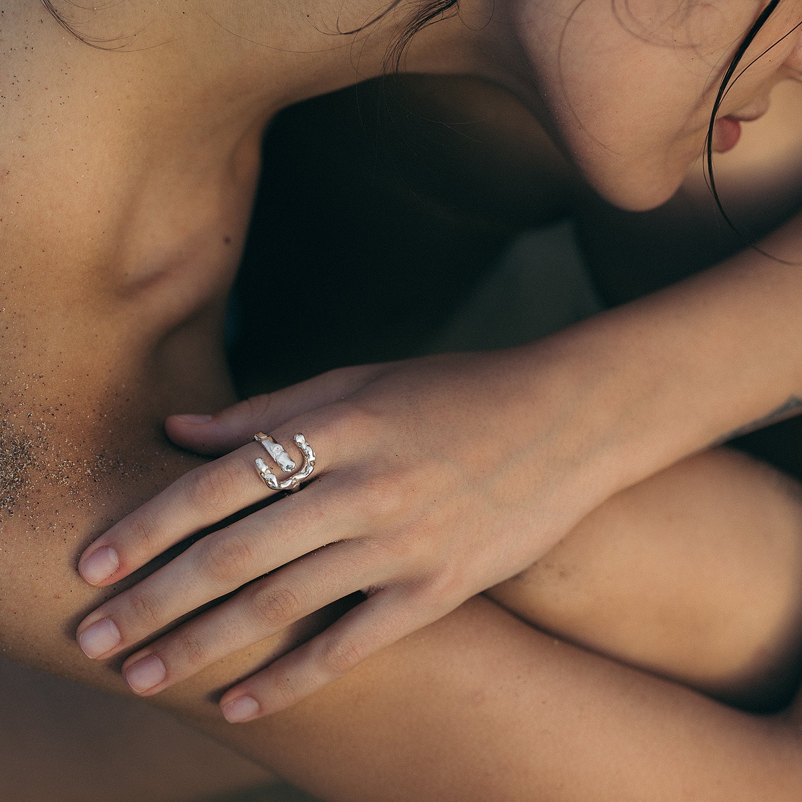 Close-up of a hand wearing a ring with a blurred background