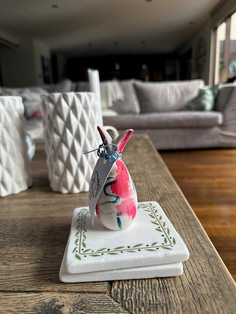 Decorative bunny on a wooden surface with a blurred background