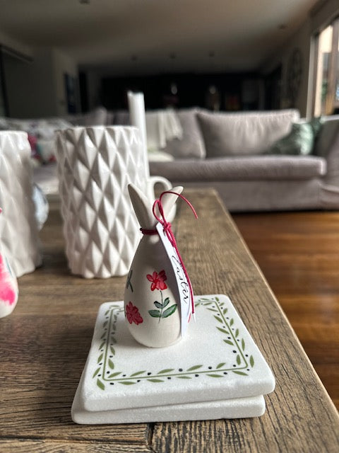 Decorative bunny on a wooden surface with a blurred indoor background