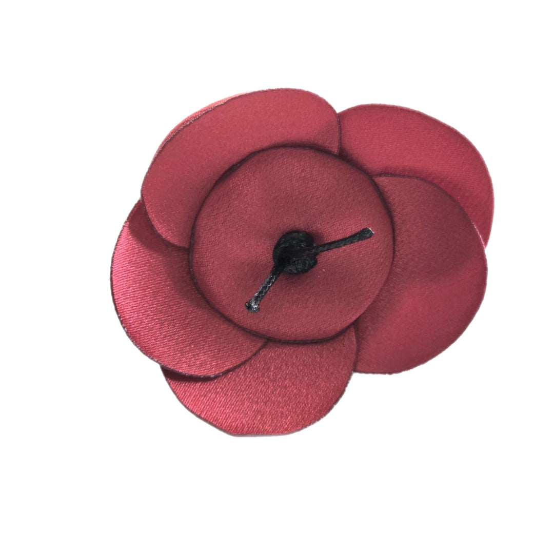 Red flower-shaped hair clip on a white background