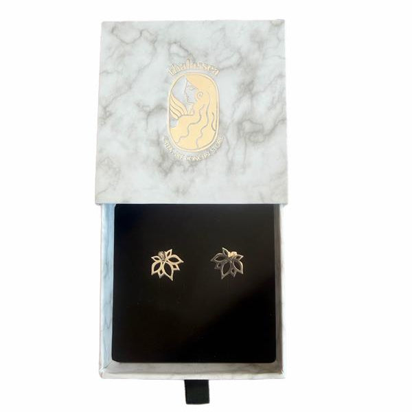 Gold leaf earrings displayed in front of a marble-patterned box.