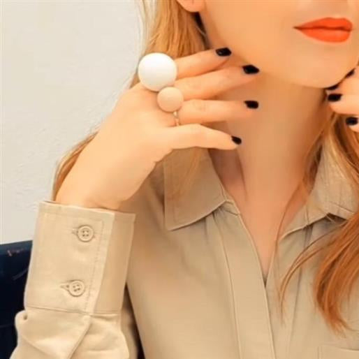 Woman wearing large round earrings with a neutral background