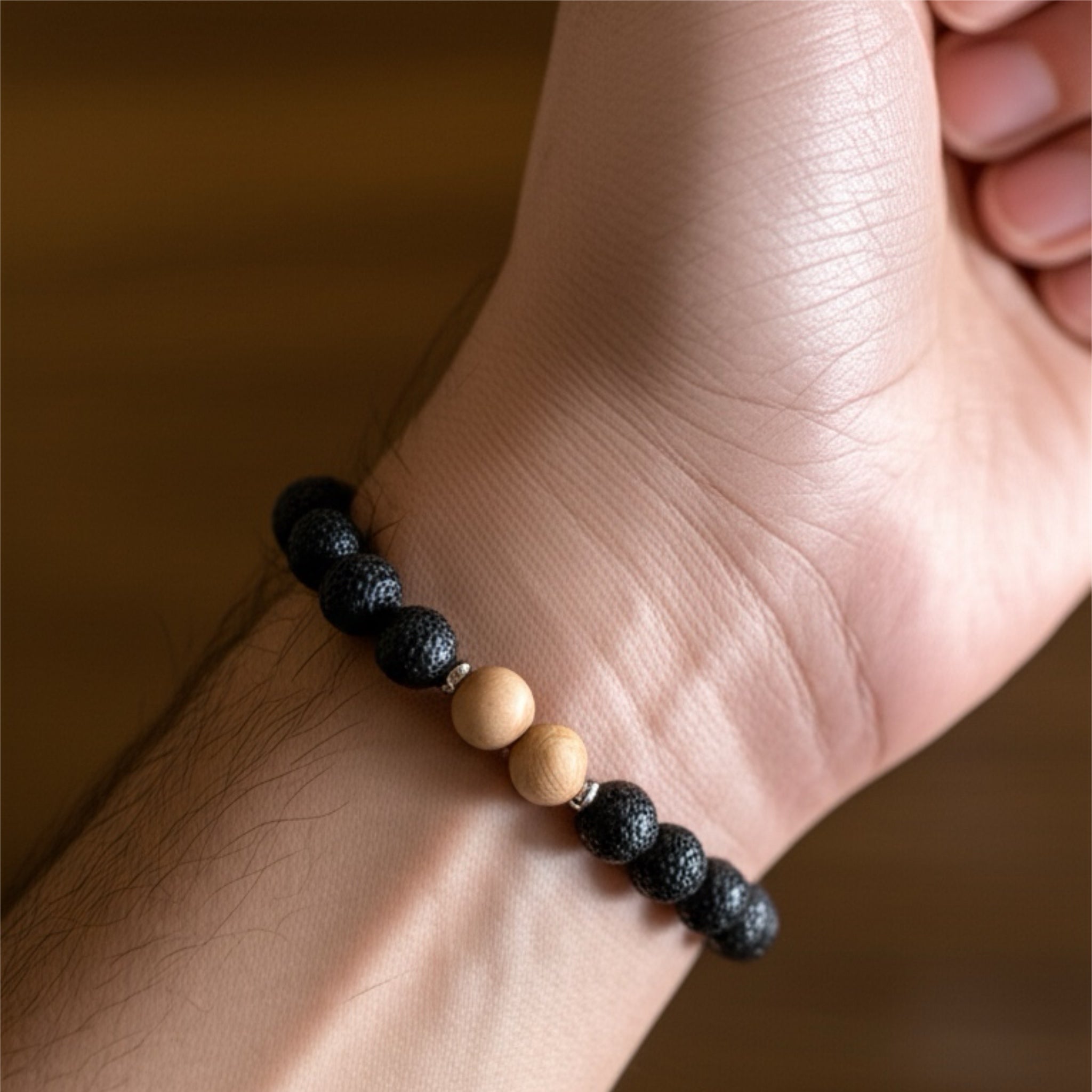 Bracelet with black and beige beads on a wrist against a blurred background