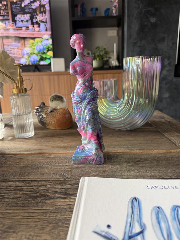 Colorful sculpture on a wooden surface with a blurred background