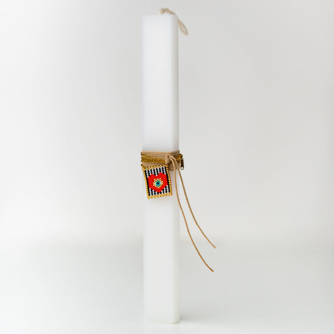 White candle with decorative packaging on a white background