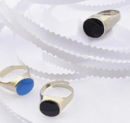 Three rings with circular stones on a textured white surface