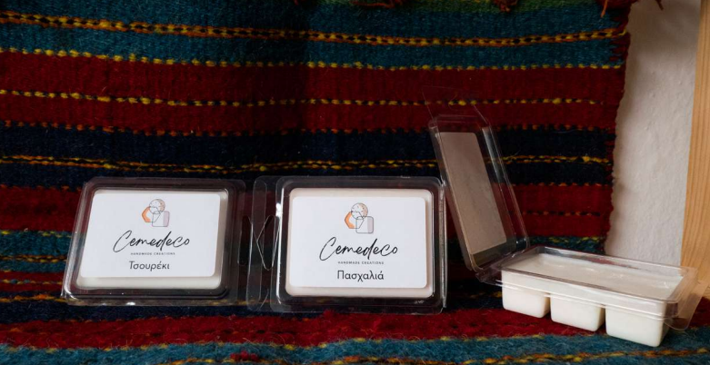 Two small containers with 'Camadeco' branding on a colorful fabric background