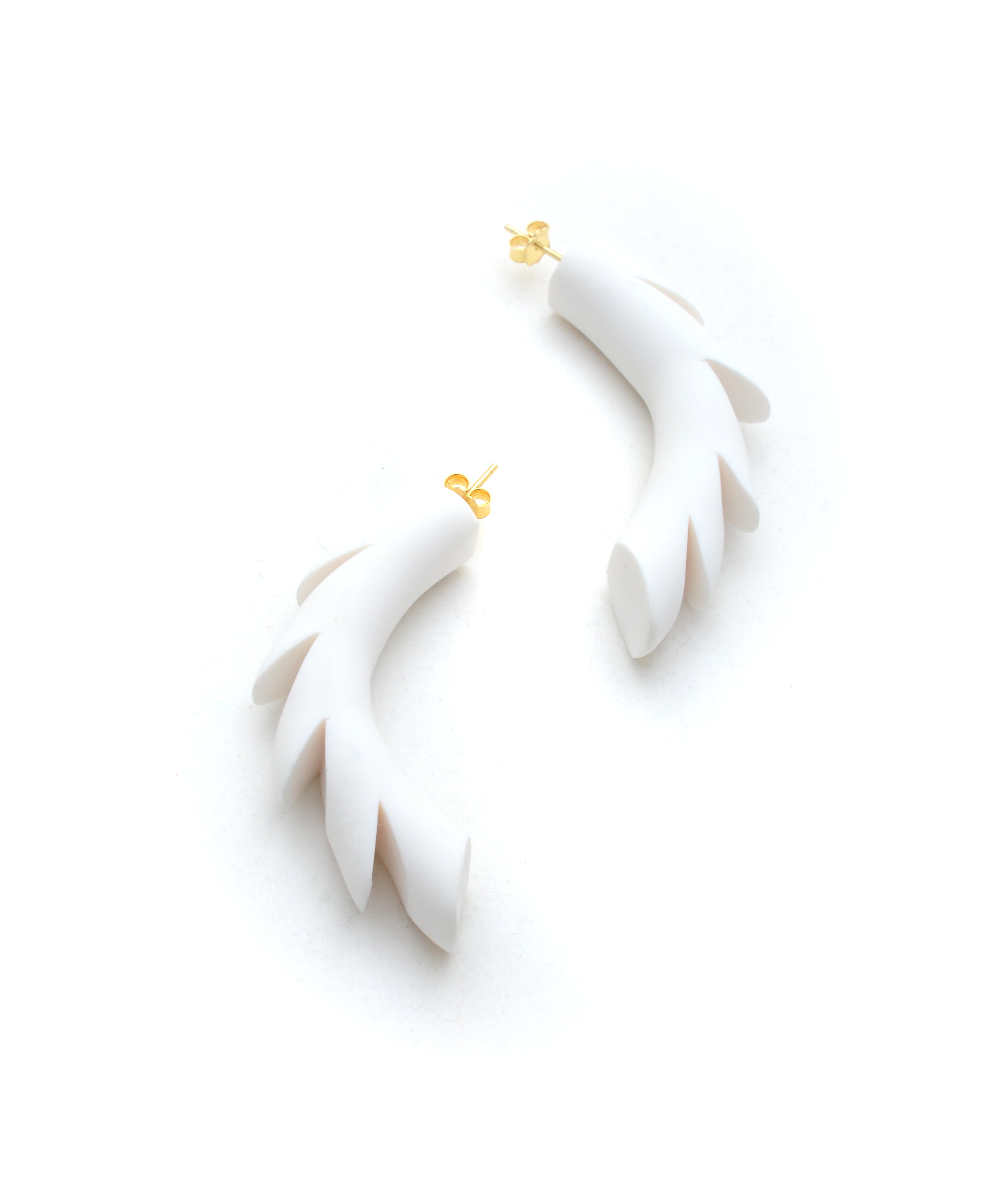 White earrings with gold accents on a white background