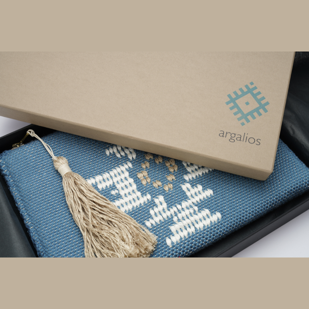 Beige box with tassel on a blue textured surface, featuring the 'argalios' brand.