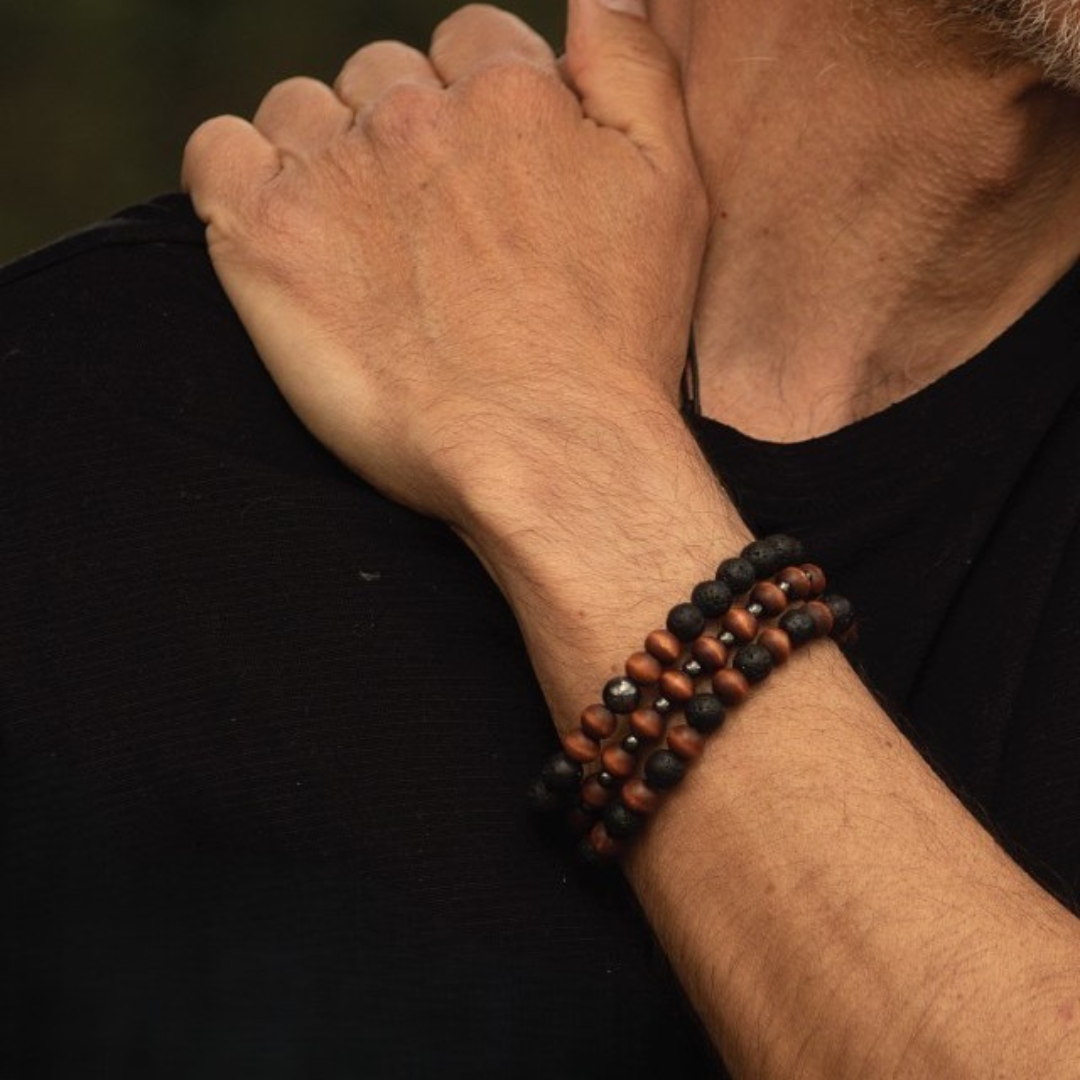 GWP Person wearing a black and orange beaded bracelet on a dark background
