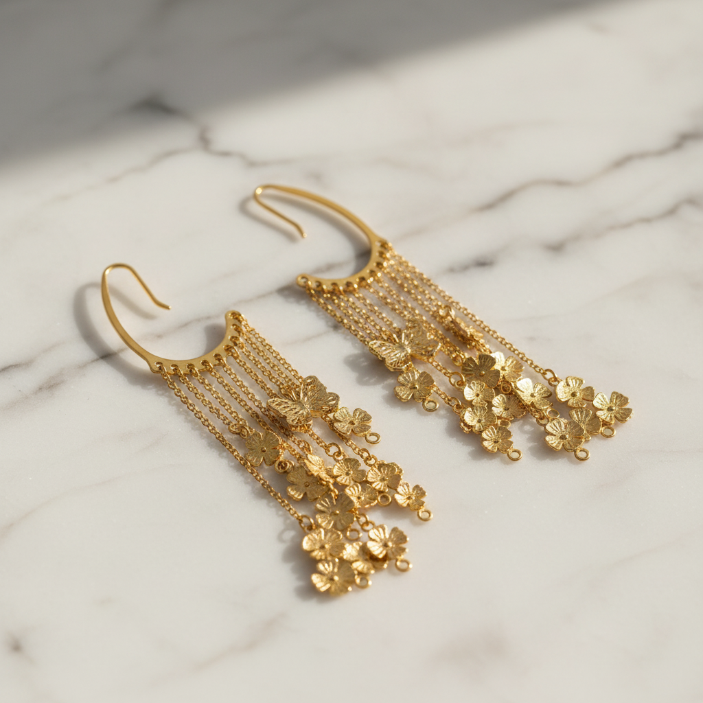 Gold floral earrings on a marble surface