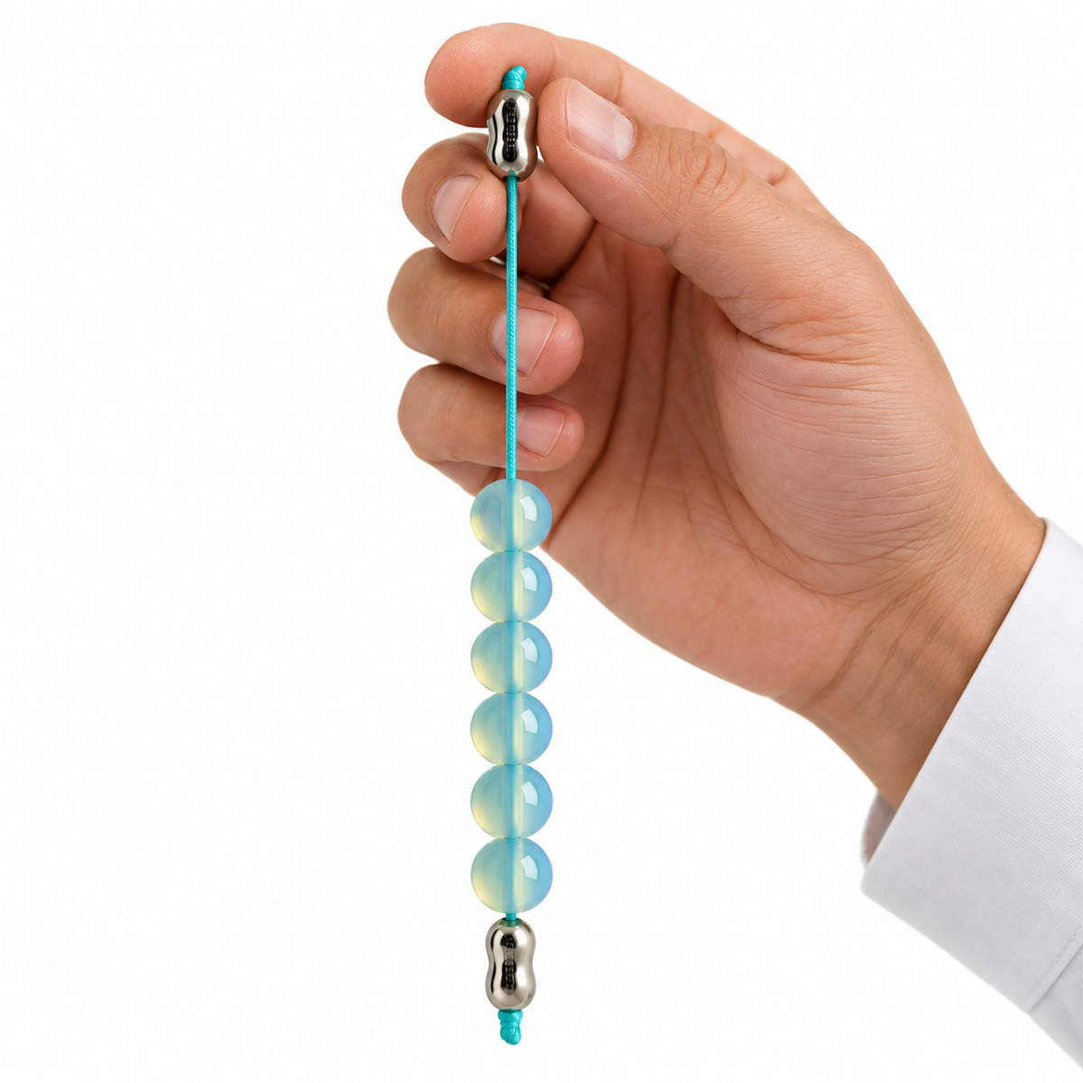A hand holding a turquoise beaded tension bandage with silver metal end caps against a white background.