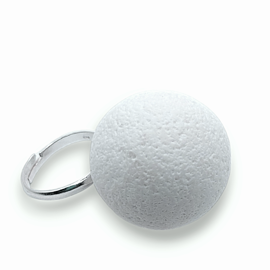 Ring with a textured white stone on a white background