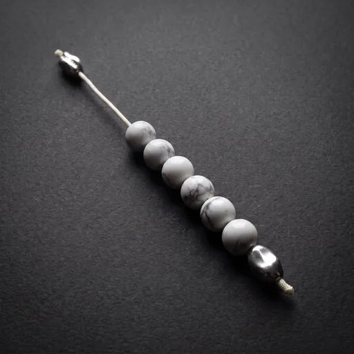A beaded nose stick or nose pin featuring five round white and gray marbled beads on a silver-toned metal rod, displayed diagonally on a dark textured background.