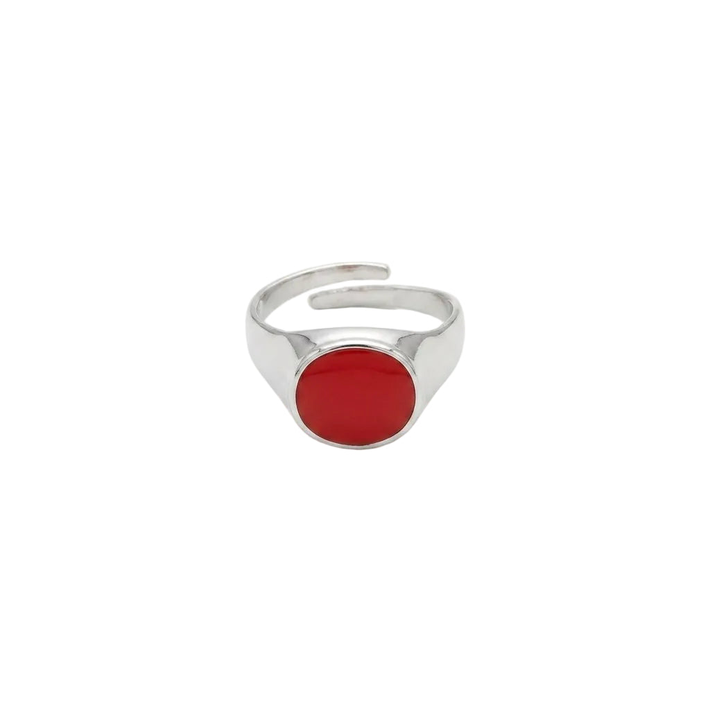 Silver ring with a red stone on a white background