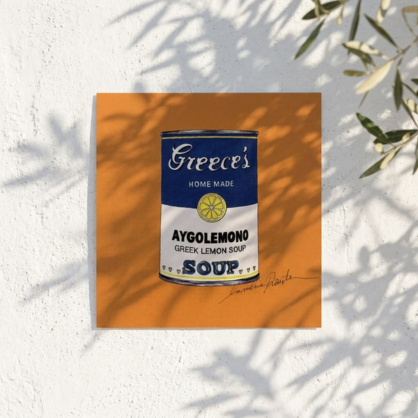 Avgolemono Orange (Small Prints Collection) – Greek pop art soup can print by Caroline Rovithi, on a sunlit white wall with olive leaves, styled | Thalassea